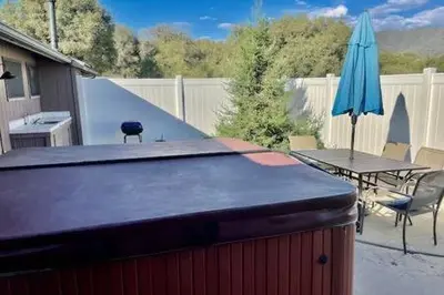 a patio with a table and a blue umbrella at Deer Haven Hot Tub Foosball Pool Table in Ahwahnee