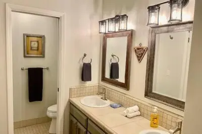 a bathroom with a sink and a toilet and a mirror at Deer Haven Hot Tub Foosball Pool Table in Ahwahnee