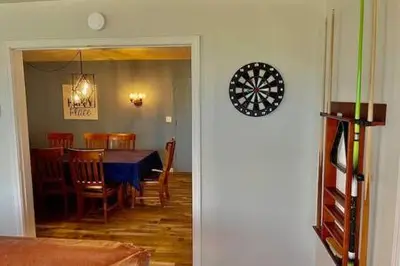 a dining room with a table and a dartboard on the wall at Deer Suite HOT TUB GAME ROOM SLEEPS 2 in Ahwahnee