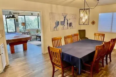 a dining room with a table and a piano at Deer Suite HOT TUB GAME ROOM SLEEPS 2 in Ahwahnee