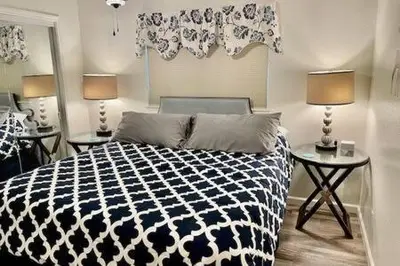 a bedroom with a black and white bed and two tables at Deer Suite HOT TUB GAME ROOM SLEEPS 2 in Ahwahnee