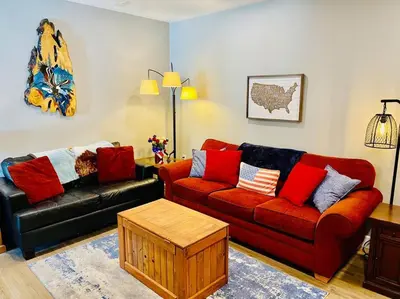 a living room with a red and black couch at Eagle Nest River Views Hot Tub Games Sleeps 6 in Ahwahnee