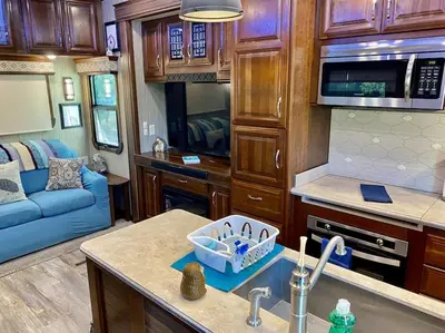 a kitchen and living room in a recreational vehicle at Happy Hedgehog River Views Hot Tub Private in Ahwahnee