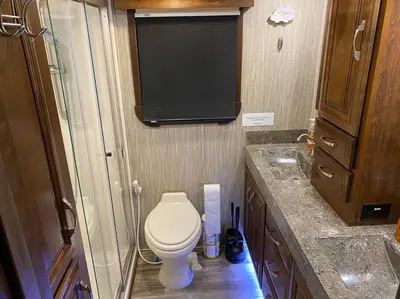 a small bathroom with a toilet and a tv at Happy Hedgehog River Views Hot Tub Private in Ahwahnee