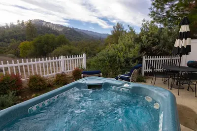 a hot tub in a yard with a table and chairs at The Funky Chicken Hot Tub BBQ SLEEPS 4 in Ahwahnee