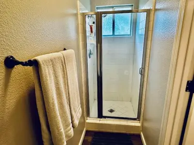 a bathroom with a shower with a glass door at The Lighthouse Pet Friendly Hot Tub BBQ Sleeps 11 in Coarsegold