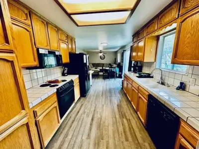 a large kitchen with wooden cabinets and appliances at Lighthouse Suite Pet Friendly Hot Tub Sleeps 4 in Coarsegold