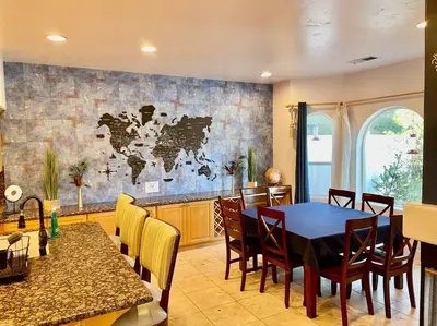 a dining room with a table and a map of the world on the wall at Peacock Suite Hot Tub Sleeps up to 4 Bbq in Ahwahnee