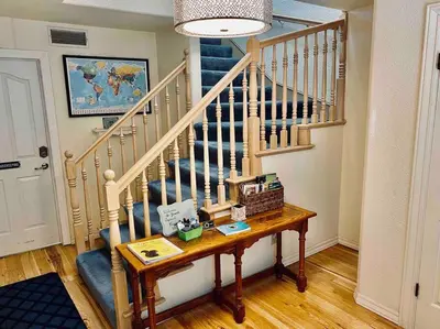 a room with a staircase with a table and a stair case at Squirrel View Hot tub BBQ Patio Shuffle Board in Oakhurst