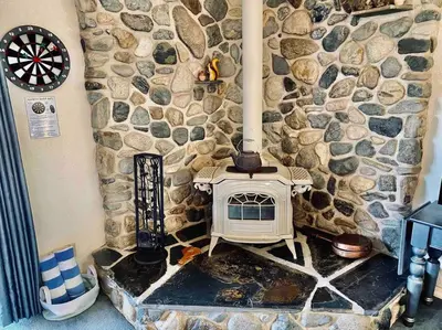 a stone wall with a stove in a room at Squirrel View Hot tub BBQ Patio Shuffle Board in Oakhurst