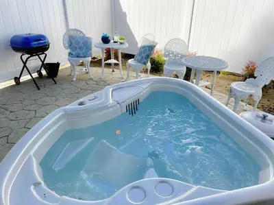 a hot tub in a yard with chairs and a table at White Feather Suite Hot Tub Private Sleeps 2 in Ahwahnee
