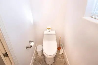 a white bathroom with a toilet with a roll of toilet paper at White Feather Suite Hot Tub Private Sleeps 2 in Ahwahnee