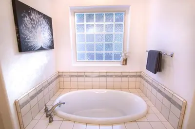 a bath tub in a bathroom with a window at White Feather Suite Hot Tub Private Sleeps 2 in Ahwahnee