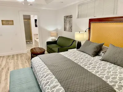 a bedroom with a large bed and a green chair at White Feather Suite Hot Tub Private Sleeps 2 in Ahwahnee