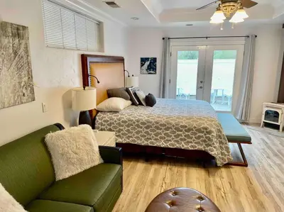 a large bedroom with a bed and a couch at White Feather Suite Hot Tub Private Sleeps 2 in Ahwahnee