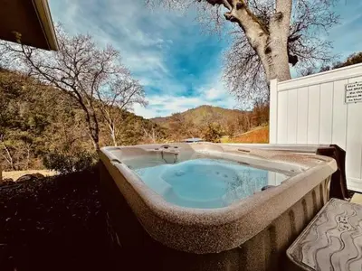 a large bath tub sitting outside of a house at Wild Stallion HOT TUB Sleeps 4 Darts Private in Ahwahnee