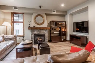 a living room with a couch and a fireplace at Woodwinds 32 in Mammoth Lakes
