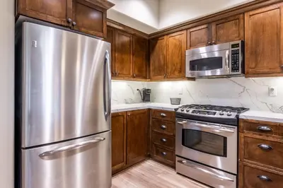 a kitchen with wooden cabinets and a stainless steel refrigerator at Woodwinds 32 in Mammoth Lakes