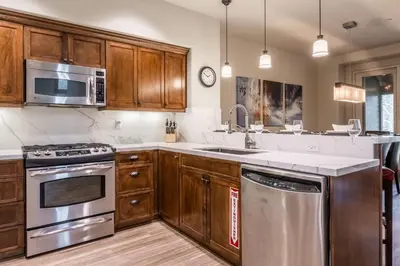 a kitchen with wooden cabinets and stainless steel appliances at Woodwinds 32 in Mammoth Lakes