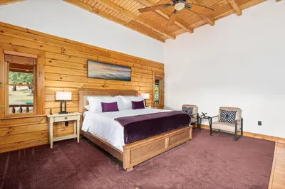 a bedroom with a bed and a ceiling fan at Yosemite Villa - log cabin with spectacular views & stargazing in Mariposa