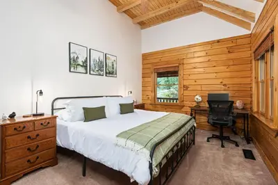 a bedroom with a bed and a desk and a chair at Yosemite Villa - log cabin with spectacular views & stargazing in Mariposa