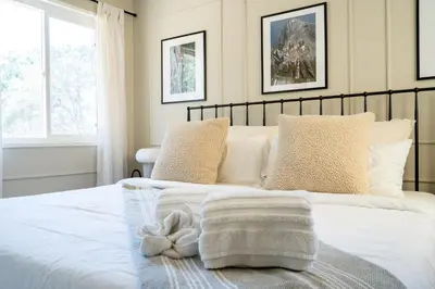 a bedroom with a bed with white sheets and pillows at Peaceful Mariposa Home near Yosemite National Park in Mariposa