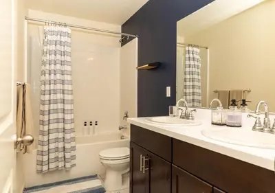 a bathroom with two sinks and a toilet at Modern 5 bed near hospitals and UC Merced in Merced