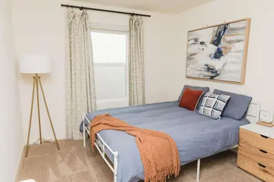 a bedroom with a blue bed and a window at Modern 5 bed near hospitals and UC Merced in Merced