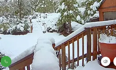 a snow covered railing on a deck at Yosemite Mountain Retreat in Oakhurst