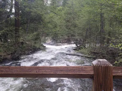 a view of a river from a wooden bridge at Yosemite Mountain Retreat in Oakhurst