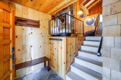 a room with wooden walls and stairs in a cabin at 5 Mi to Donner Lake Cabin with Deck and Pool Access! in Truckee