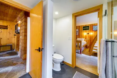 a bathroom with a toilet and a bedroom at 5 Mi to Donner Lake Cabin with Deck and Pool Access! in Truckee