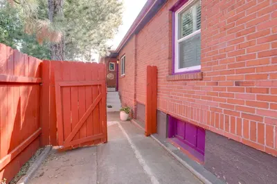 a red brick house with a fence and purple doors at Hot Tub and Grill Pet-Friendly Apt, Walk to Midtown in Reno