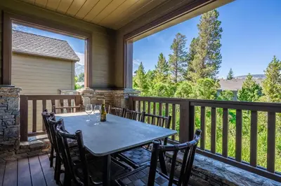 a patio with a table and chairs on a deck at Creekhouse 1583 in Mammoth Lakes