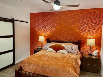 a bedroom with a bed with a orange wall at Foxs Den Hot Tub Bbq Queen Bed Sleeps 2 in Ahwahnee