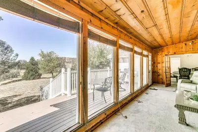 a screened in porch with a couch and chairs at Spacious Coarsegold Getaway about 34 Mi to Yosemite! in Coarsegold
