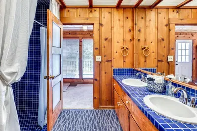 a bathroom with two sinks and wooden walls at Spacious Coarsegold Getaway about 34 Mi to Yosemite! in Coarsegold