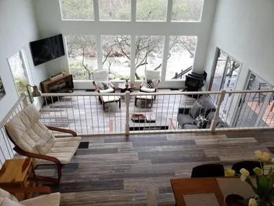a living room with furniture and a large window at Sierra River House 5 min to Sequoia Park Entrance in Three Rivers