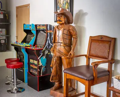 a statue of a cowboy sitting on a chair next to a slot machine at Sierra River House 5 min to Sequoia Park Entrance in Three Rivers