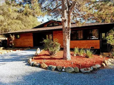 a house with a tree in front of it at Sequoia River House, close to SNP, 2 Decks on Amazing River on 7acres in Three Rivers