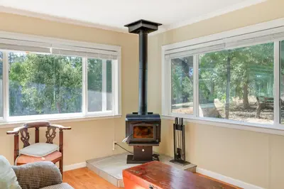 a living room with a wood stove in the corner at Groveland Vacation Rental with Private Deck and Grill! in Groveland