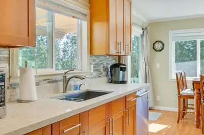 a kitchen with wooden cabinets and a sink at Groveland Vacation Rental with Private Deck and Grill! in Groveland