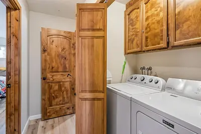 a kitchen with a washer and dryer and wooden cabinets at Water's Edge - Gorgeous Water Views! home in Groveland