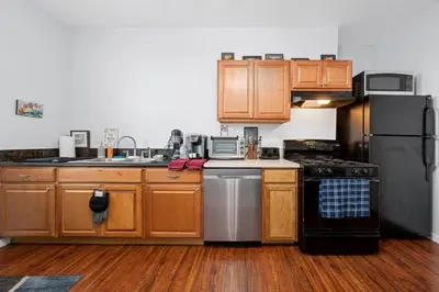 a kitchen with wooden cabinets and stainless steel appliances at Cozy 1 bdr/1br near downtown in Sacramento