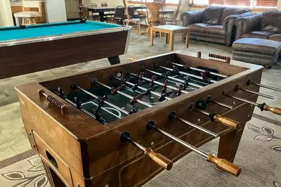 a pool table in a living room with a chest filled with guns at St Moritz 55 F in Mammoth Lakes