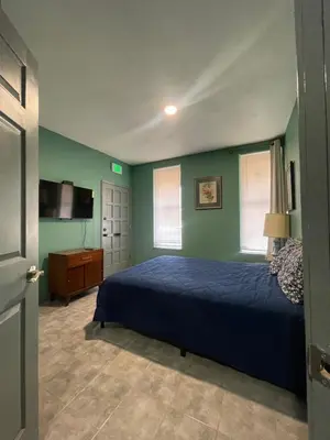 a bedroom with a blue bed and a television at Fresno Vacation Rental 106 in Fresno