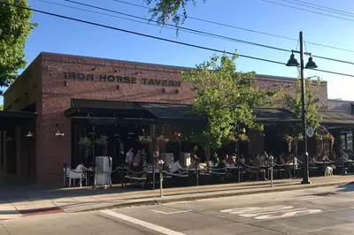 a brick building with people sitting at tables in front at Smart Eclectic ART HOUSE near the beat in Sacramento