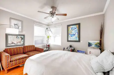 a bedroom with a bed and a couch and a ceiling fan at Smart Eclectic ART HOUSE near the beat in Sacramento