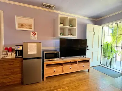 a living room with a tv and a refrigerator at Sweet Home with Ample Parking Only 2mins to Freeway in Sacramento