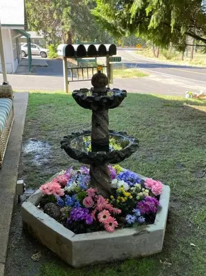 a fountain in a flower garden in a park at Fairway Apartments Unit 1 in Twain Harte